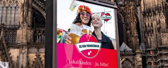 Citylight Plakat vor dem Kölner Dom zum Thema Lokal kaufen